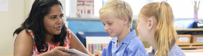Teacher interacting with two young students