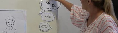 Teacher sticking 'help me' sign onto whiteboard